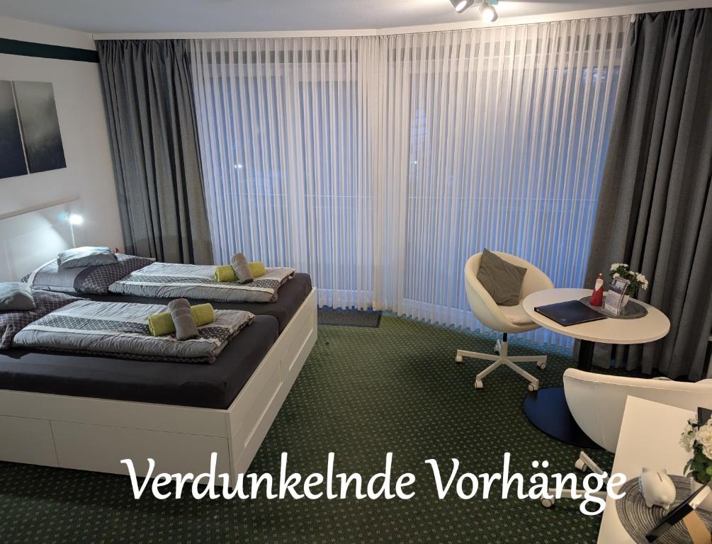 een slaapkamer met twee bedden, een bureau en een stoel bij Apartment "Waldrand" mit Balkon und Pool - Renoviert 2026 in Bad Essen