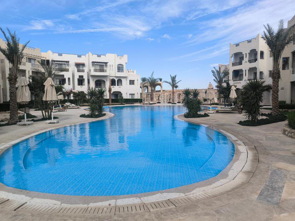 拉斯苏德尔la Hacienda Cozy Studio Chalet的一座大型游泳池,位于部分建筑前