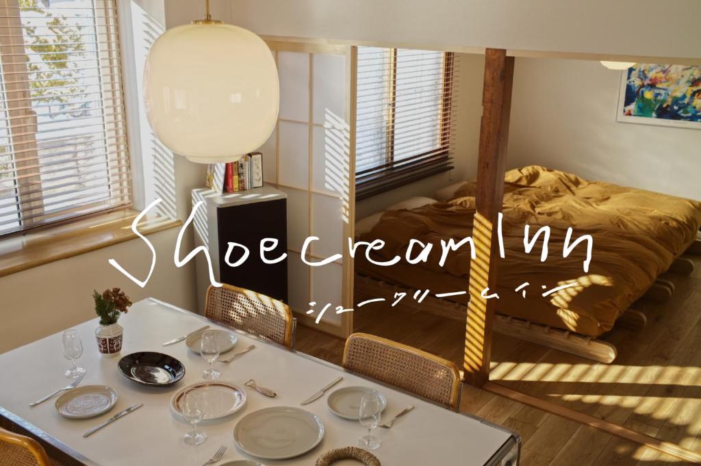 a dining room with a table and a bed at Shoe Cream Inn Higashikawa in Higashikawa