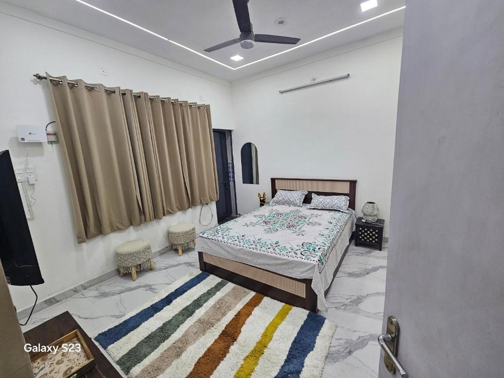 a bedroom with a bed and a television in it at AnjuShyam HomeStay in Agra