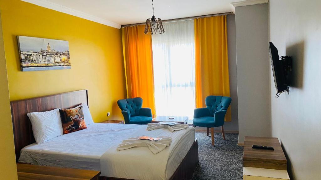 een hotelkamer met een bed en stoelen en een raam bij Ay suit in Esenyurt