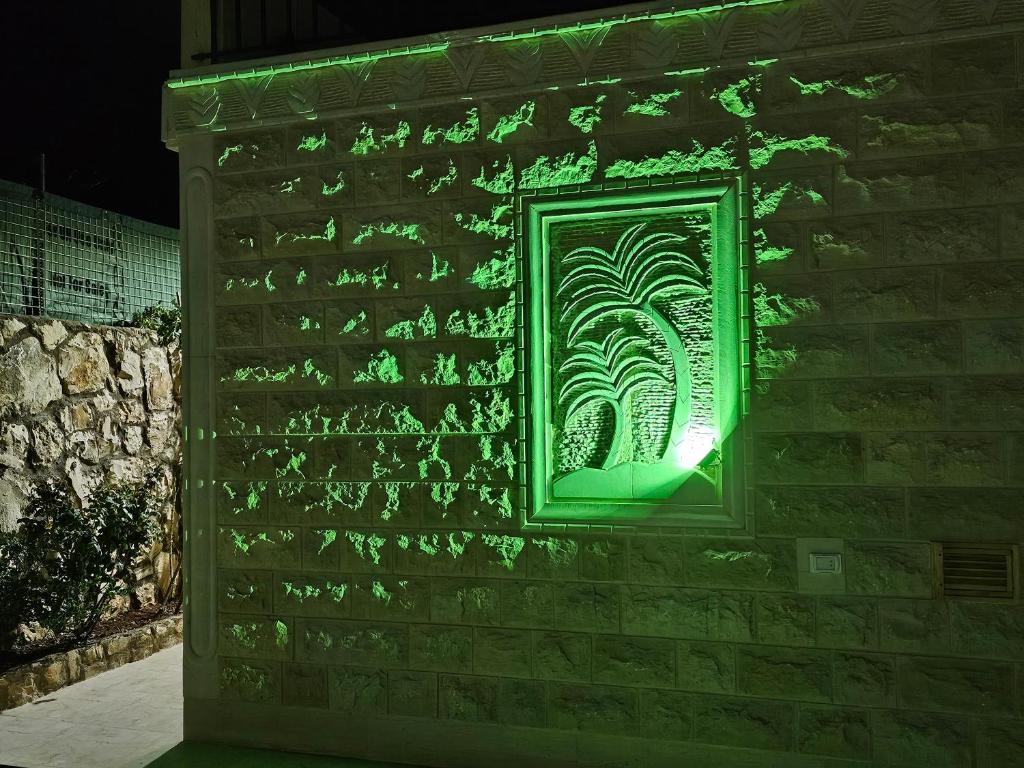 a window on a brick wall with green lights at شالية بيتي in El Hoûé