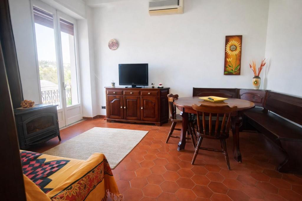 a living room with a table and a television at CasaTreFontane in Bovalino Marina