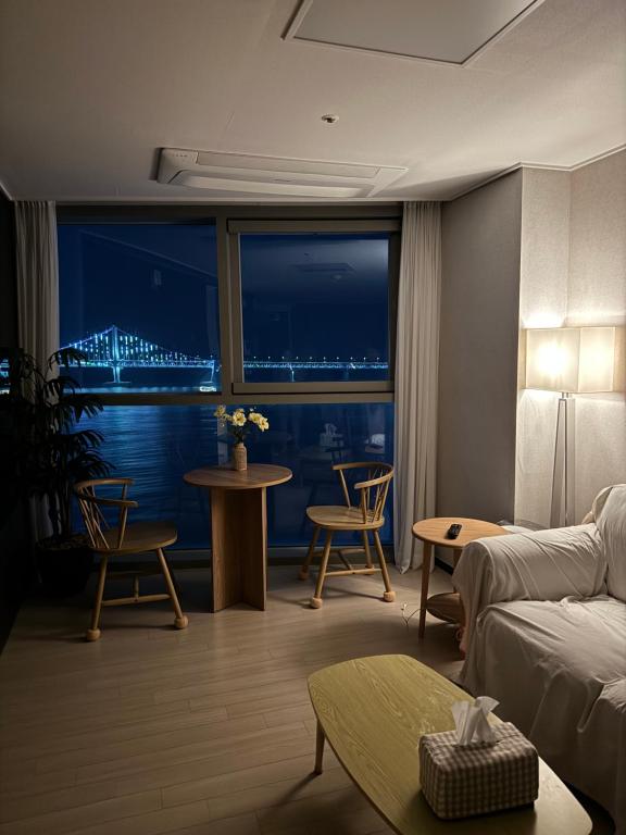 een woonkamer met een bank en een tafel met stoelen bij Gwangan cozy in Kwangan-dong