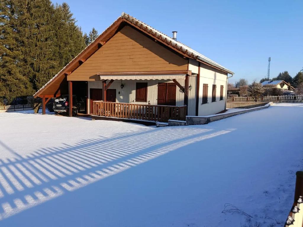 a house in the snow with its shadows on the ground at Location d'un chalet de vacances in Pont-de-Poitte