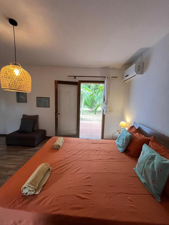 a large bed with an orange blanket in a room at Thelazycoco in Blue Bay