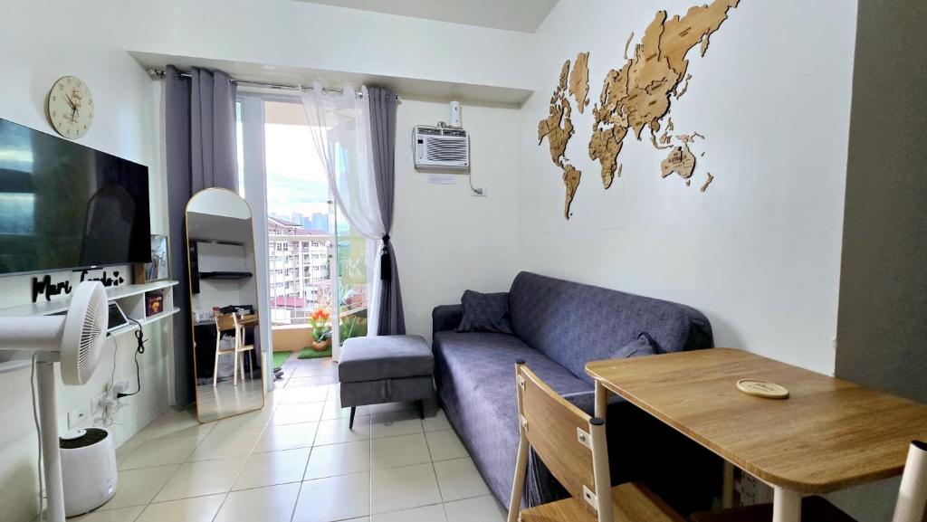 un soggiorno con un divano blu e un tavolo di Mari Condo Hostel a Manila