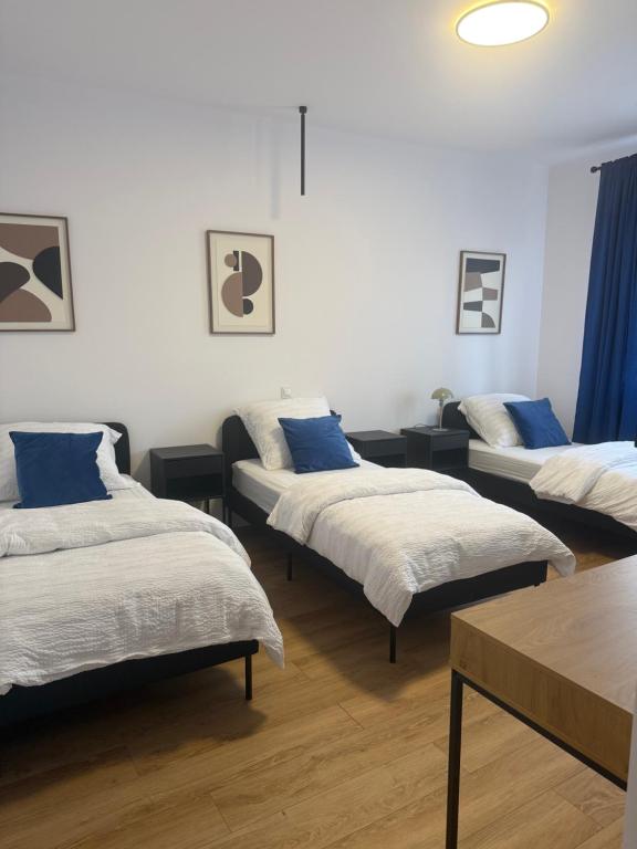 a room with three beds with blue pillows at MW 4A Apartament in Rzeszów
