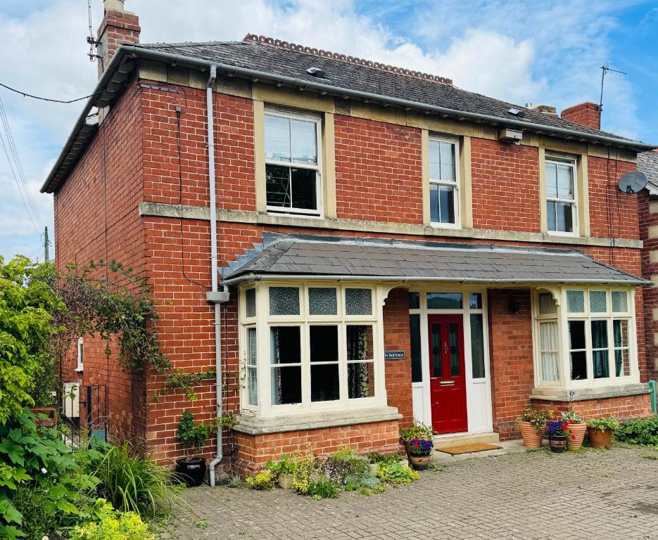 a red brick house with a red door at Spacious Edwardian home in Stroud