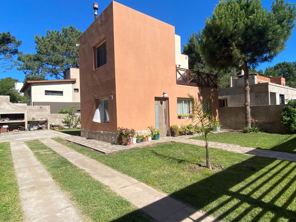 a house with a tree in the yard at FloreSer in Villa Gesell