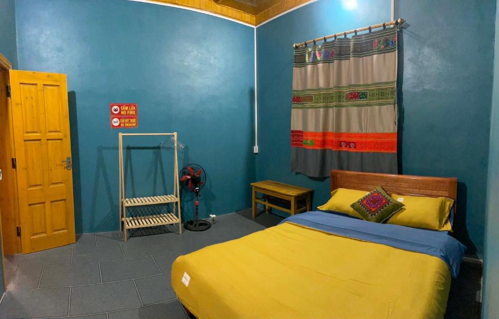 a bedroom with a yellow bed and a blue wall at MaMa ShuShu Homestay in Sapa
