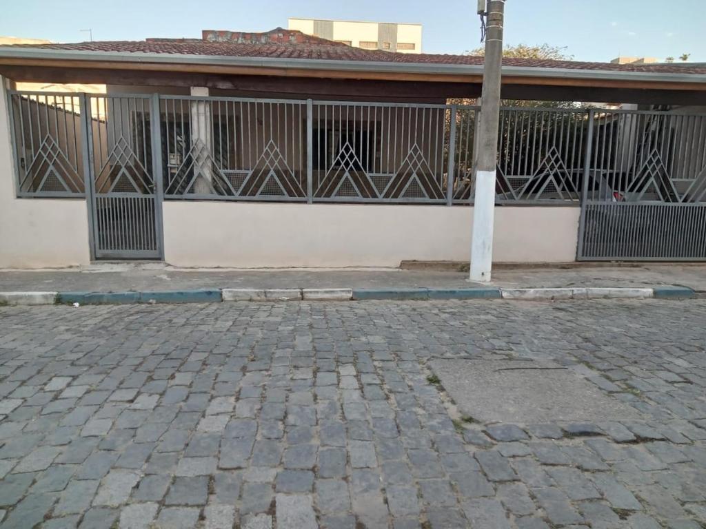 a building with a gate and a brick street at Aconchego de mae - 5 min do Santuário e comércios - Casa completa in Aparecida
