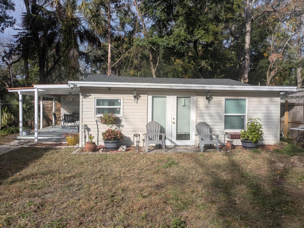 a small white house with two chairs in a yard at Cottage & Garden in Jacksonville