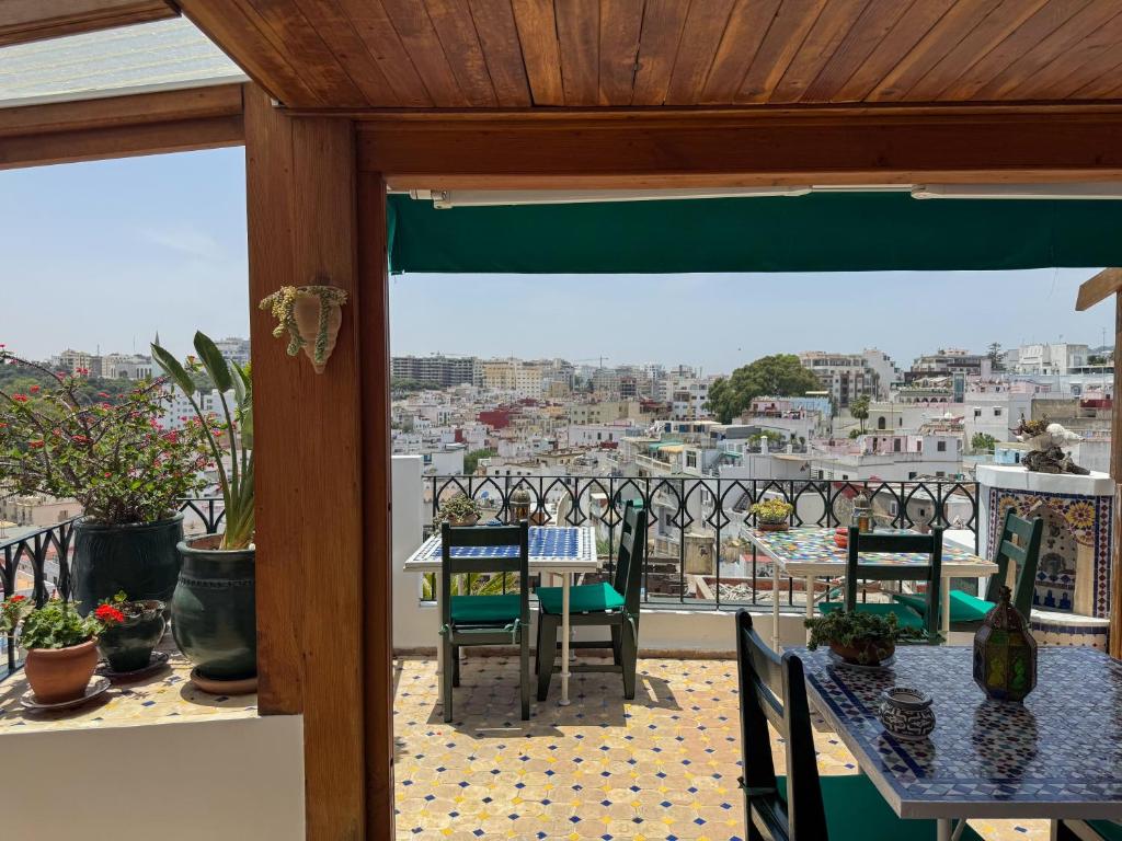 een balkon met tafels en stoelen en uitzicht op een stad bij Kasbah Rose in Tanger