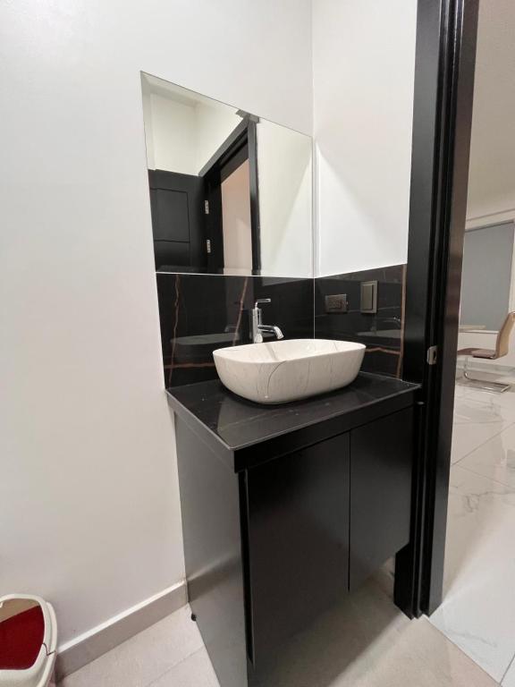 een badkamer met een wastafel en een spiegel op een aanrecht bij El Lago in Coronado