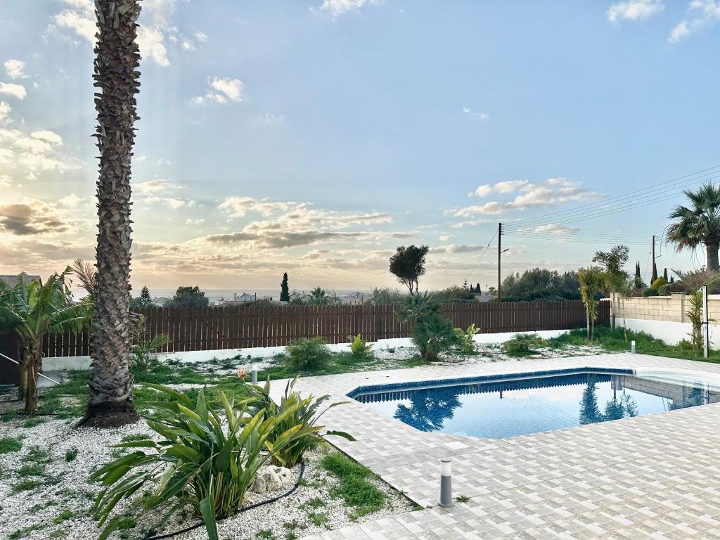 a swimming pool in a yard with a palm tree at Casa Elea in Kouklia