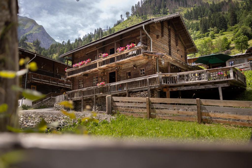 a wooden building with flowers on the balcony at Chalet Mühlburger in Gruben