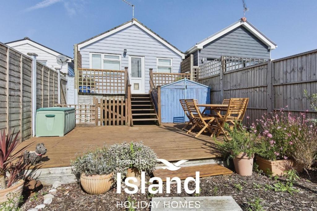 a backyard with a wooden deck with a table and chairs at 28 Marsh Road in Gurnard
