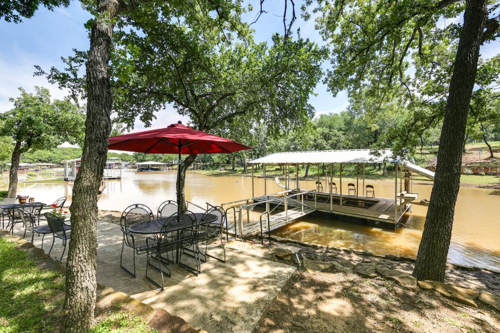 a picnic table with an umbrella in front of a river at Papas Lakefront Hideaway in Chico