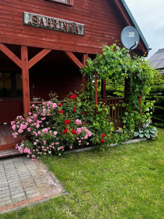 a garden of flowers in front of a building at Domek Sabrinka in Słajszewo