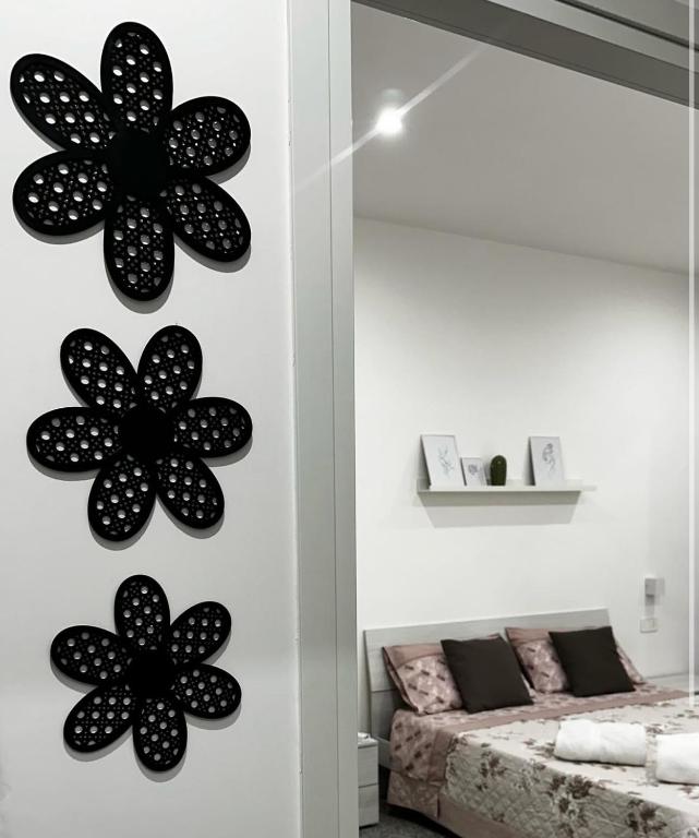 a bedroom with black flowers on the wall at Black Daisy in Bernalda