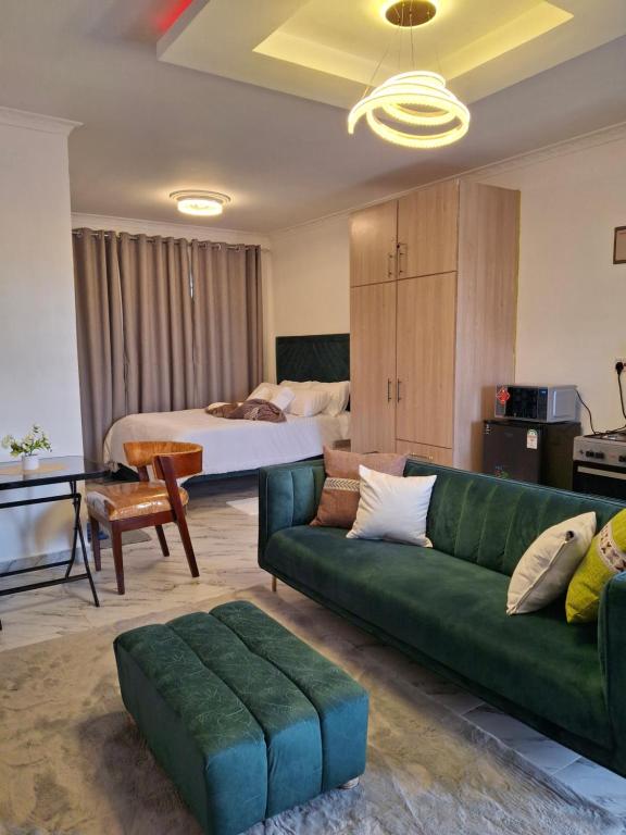 a living room with a green couch and a bed at Unique Comfort Stay in Nanyuki