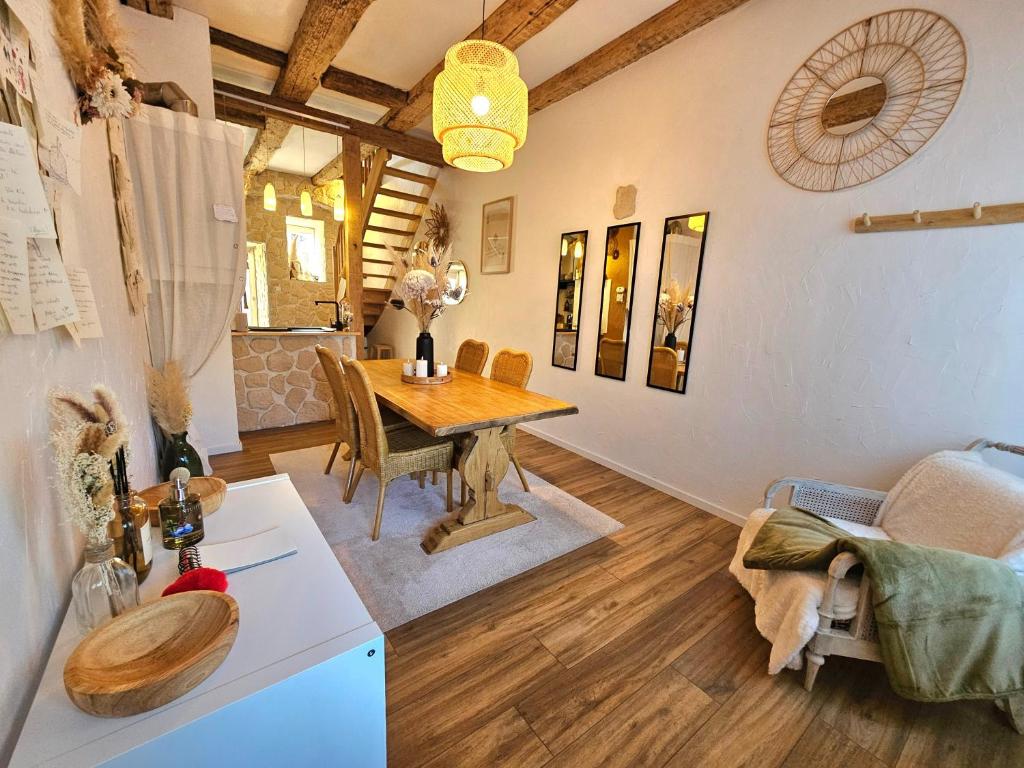 a room with a wooden table and a dining room at L'Atypique des Remparts in Ensisheim