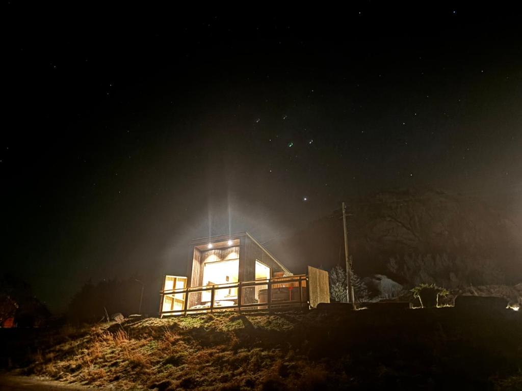 a small house on a hill at night at Unik og moderne microhytte med utsikt mot havet 40 A Otterlei Resort in Longva