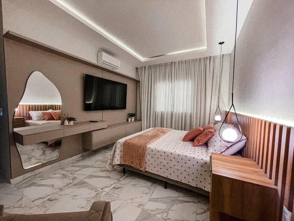 una camera da letto con un letto e una TV a parete di Life House Ubajara a Ubajara