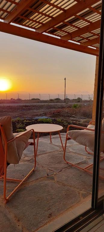 a table and two chairs and a table and a sunset at שיר ערש in Giv'at Yo'av