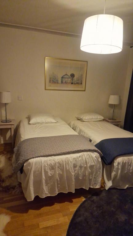 two twin beds in a bedroom with a chandelier at Cosig house in Nygård