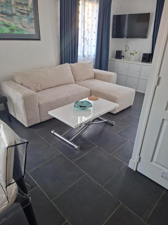a living room with a couch and a table at villa méditerranéé in Vias