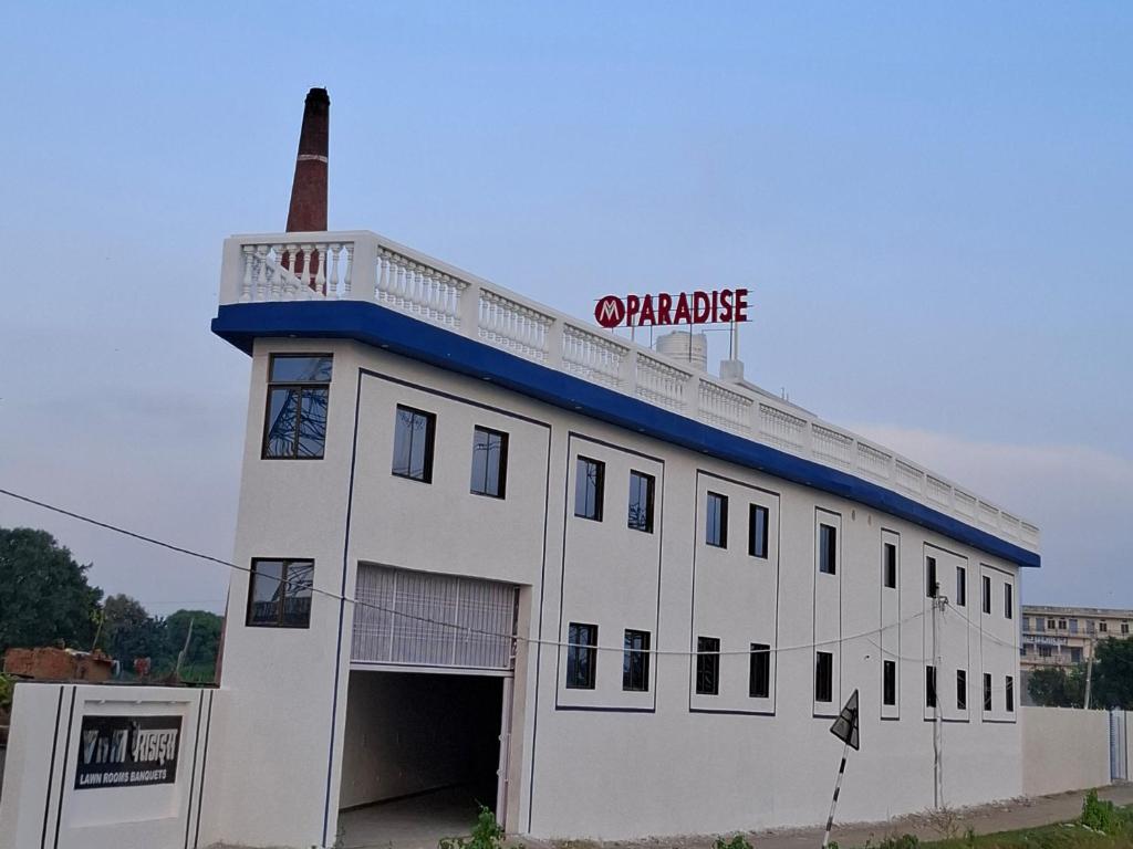 a white building with a blue roof and a garage at VnM Paradise in Chunār