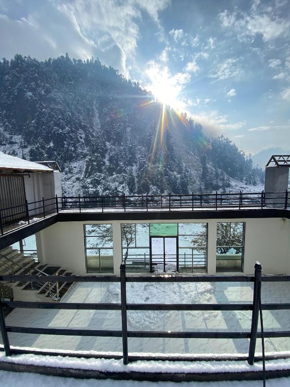 a view of a snow covered mountain with the sun in the sky at Comfort Inn in Kalām