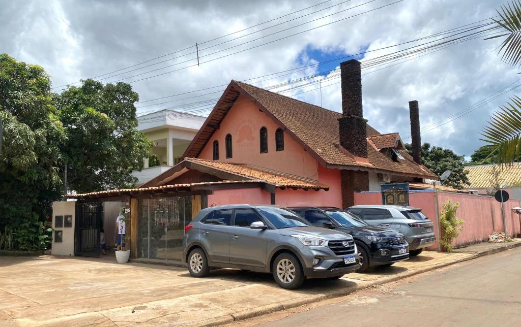 two cars parked in front of a house at Casa Astral in Chapada dos Guimarães