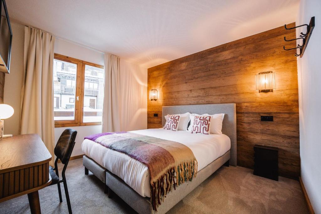 ein Hotelzimmer mit Bett und Schreibtisch in der Unterkunft Hotel Emeraude in Peisey-Nancroix