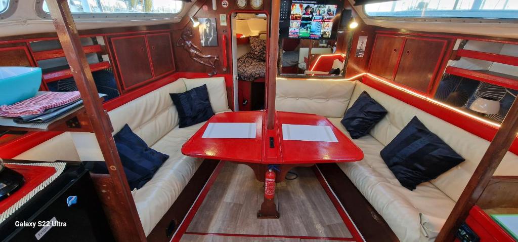 een rode tafel achterin een boot bij Voilier de tout confort in Cherbourg en Cotentin
