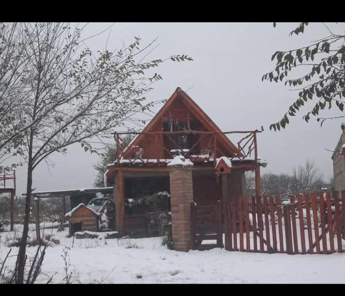 a log cabin in the snow with a fence at Casita Walden in Cosquín