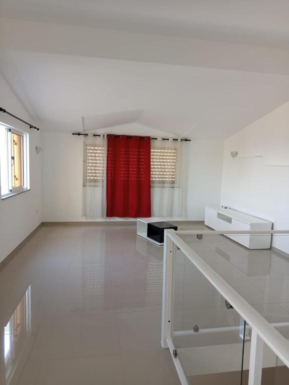 a large white room with a red curtain in a room at Casa Melissa in Ponta do Sol