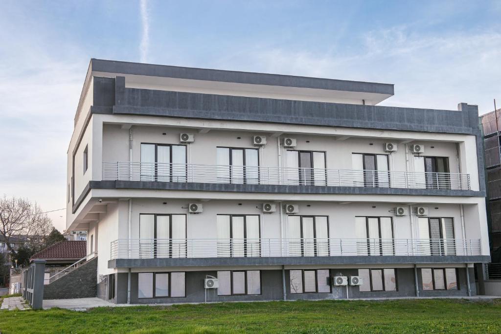 a white building with a balcony on top of it at Pensiunea EDY in Mangalia