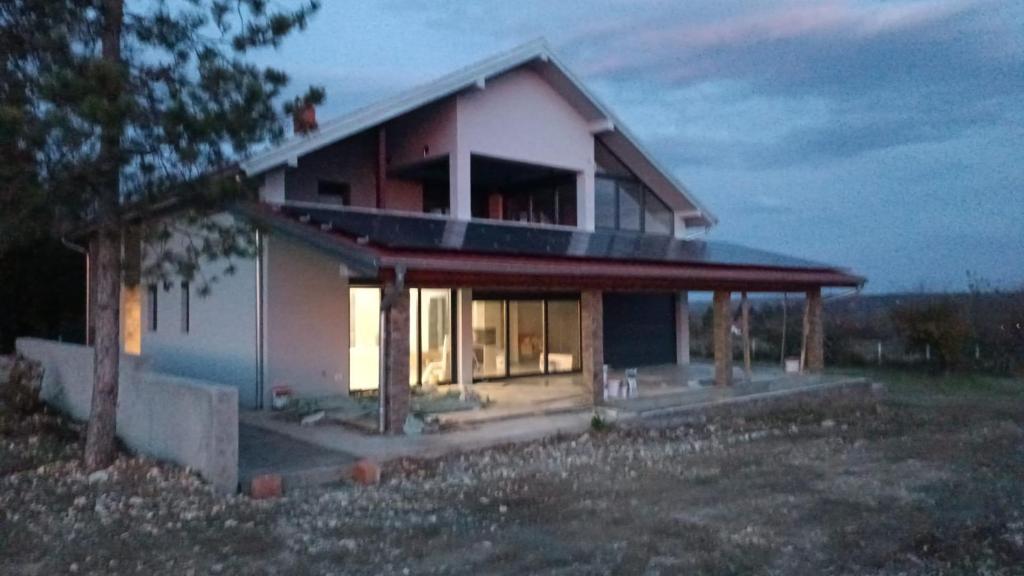 a house with the lights on inside of it at Lakeview Apartment & Spa in Belosavci