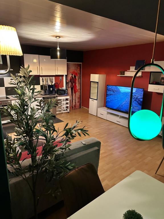 een woonkamer met een grote televisie en een keuken bij Green Seeblick Hotel am See in Obermaubach