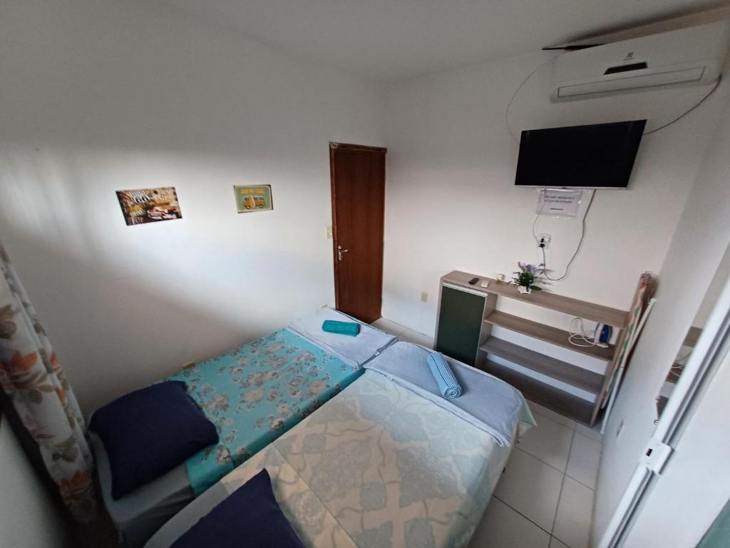 una piccola camera da letto con un letto e una TV a schermo piatto di Studio Com Ar Condicionado na Manoel Novais a Serrinha