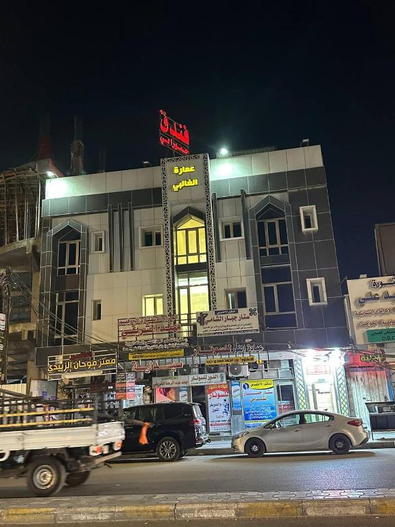 a building with cars parked in front of it at فندق حمورابي Hammurabi Hotel in An Nāşirīyah