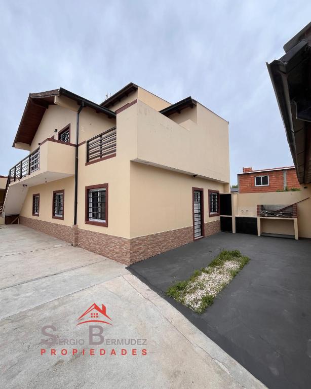 a house with a driveway in front of it at Departamento del Tuyu in Mar del Tuyú