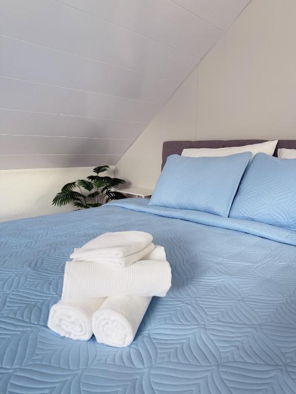 un letto blu con sopra asciugamani di Helles & Modernes Apartment in Heilbronn a Heilbronn