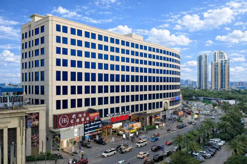 een hoog wit gebouw in een straat met verkeer bij 东方酒店 in Sihanoukville