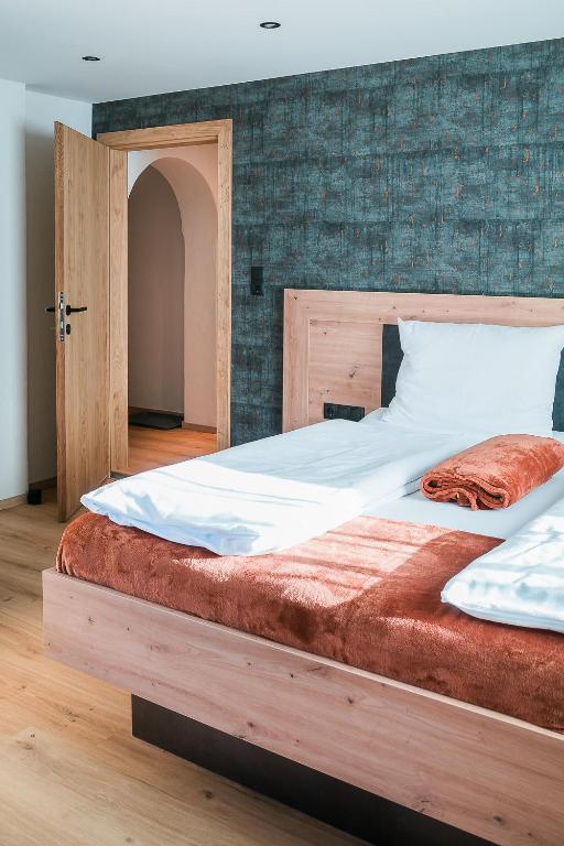 a large bed with a wooden frame in a room at die Harmonie in Nauders
