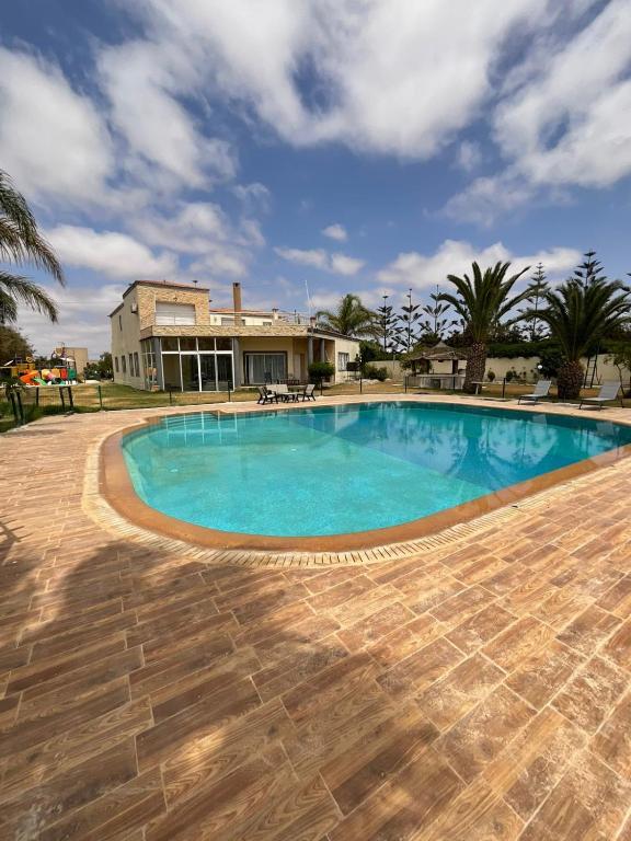 a large swimming pool in front of a house at Villa Prestige avec piscine in Tamaris