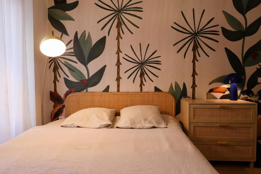 une chambre avec un lit et des plantes accrochées au mur dans l'établissement Studio tropical, au Puy-en-Velay
